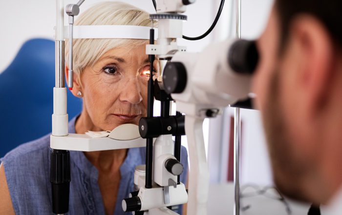 Retina specialist examining patient's eyes with medical instruments in a clinic